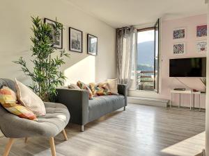 a living room with a couch and a tv at Charmant appartement avec terrasse parking in Ispagnac