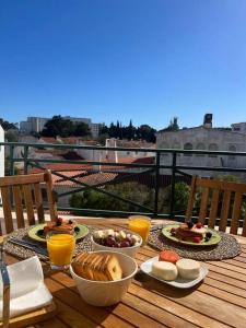 einen Tisch mit Frühstückszutaten und Getränken auf dem Balkon in der Unterkunft Apartamento Falésia c/ Piscina in Albufeira