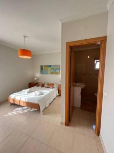 1 Schlafzimmer mit einem großen Bett und einem Badezimmer in der Unterkunft Apartamento Falésia c/ Piscina in Albufeira