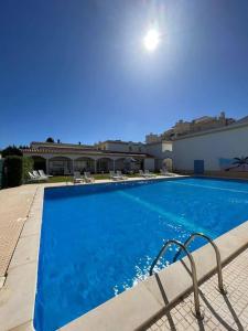 ein großer blauer Pool neben einem Gebäude in der Unterkunft Apartamento Falésia c/ Piscina in Albufeira