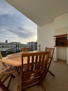 einen Holztisch und Stühle auf dem Balkon in der Unterkunft Apartamento Falésia c/ Piscina in Albufeira
