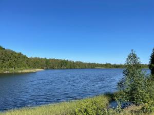 a large body of water with trees in the background at Cottage with beautiful nature, open landscape, forest and lakes I X I Stuga med fin natur, öppna landskap, skog och sjöar in Tingsryd