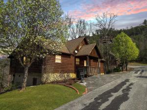 a log cabin house with a road in front of it at Lazy Bear Den in Sevierville