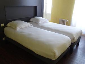 two beds sitting next to each other in a room at LA CROIX D'OR LOGIS Hôtels in Le Faouët