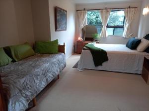 a bedroom with a bed and a couch and a window at Birds Eyes Te Awanga in Te Awanga