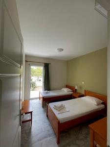 トロにあるPorto Assiniのベッド2台と窓が備わるホテルルームです。