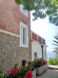 a brick building with flowers in front of it at Villa Pino in Furore