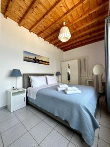 a bedroom with a large bed and a wooden ceiling at Villa Oceania in Tourlos