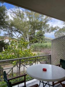 a balcony with a table and chairs and a tree at Porto Assini in Tolo