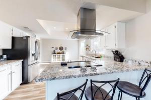 a kitchen with white cabinets and a black refrigerator at Pleasant Daydreams in Chandler