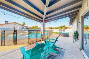 a patio with two green chairs and a swimming pool at Pleasant Daydreams in Chandler