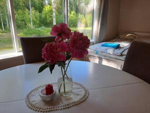 a vase of pink flowers sitting on a table at Nedsaja metsamaja ja saun in Nedsaja