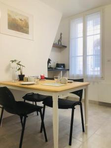 a dining room table with two chairs in a kitchen at LE GITE DE LA GIRAFE CENTRE VILLE LOUVIERS in Louviers +3 photos