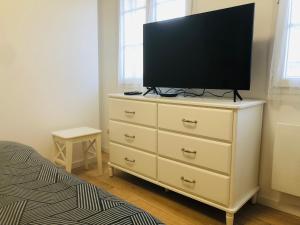 a bedroom with a dresser with a flat screen tv on it at LE GITE DE LA GIRAFE CENTRE VILLE LOUVIERS in Louviers