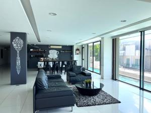 a living room with a couch and a table at The Pixels Cape Panwa Condo in Phuket Town