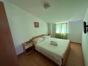 a bedroom with a white bed and a window at Apartments Brkić in Lozovac