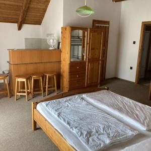1 dormitorio con 1 cama y cocina con taburetes en Post Apartman, en Balatonmáriafürdő