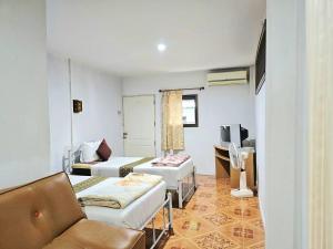 a room with a living room with a couch and a tv at P.California Inter Hostel in Nang Rong