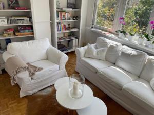 a living room with two white couches and a table at KernerApartement in Stuttgart