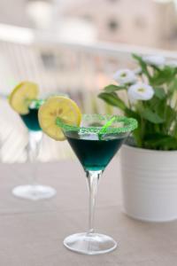 a blue drink in a glass with a lemon slice at Apartments Miljanic in Cavtat
