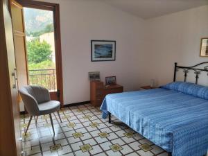a bedroom with a bed and a chair and a window at Villa Rizzo in Castellammare del Golfo