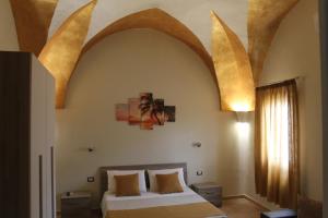 una camera da letto con un letto con un grande arco sopra di esso di B&B Lizia a Porto Cesareo