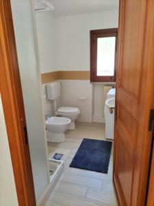 a bathroom with a toilet and a blue rug at Villa Rizzo in Castellammare del Golfo