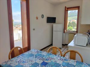 a small kitchen with a table and a refrigerator at Villa Rizzo in Castellammare del Golfo