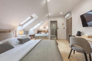a bedroom with a large bed and a tv at Hotel Zátoka in Holčíkovce