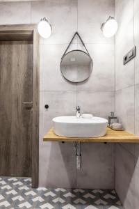 a bathroom with a sink and a mirror at Hotel Zátoka in Holčíkovce +53 photos
