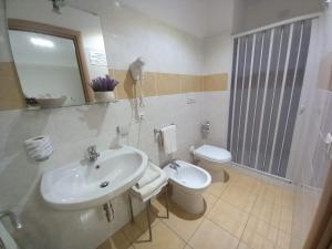 een badkamer met een wastafel, een toilet en een spiegel bij Al Giglio - Bed and Breakfast in Cariati