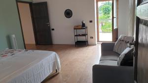 - une chambre avec un lit, un canapé et une fenêtre dans l'établissement Casale di Maro, à Monte Giberto