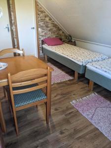 a room with two beds and a table and a chair at Pärna Guesthouse & Apartments in Kuressaare