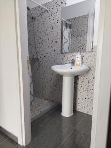 a bathroom with a sink and a shower at Saranda Boutique Hostel in Sarandë
