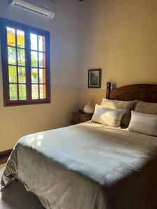 a bedroom with a large bed and a window at Chácara das Lendas e Canções in Passa Quatro