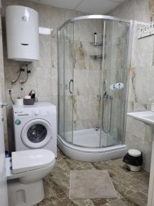 y baño con ducha y lavadora. en Luxury Central Apartment, en Strumica