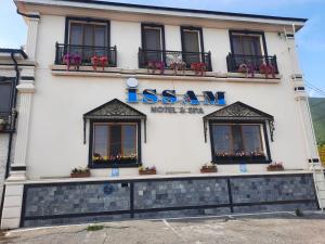 a building with a sign on the side of it at Issam Hotel & Spa Sheki in Sheki