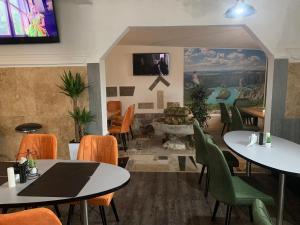 un restaurante con mesas y sillas y TV en la pared en APARTMANI & RESTORAN -S O K O- SJENICA, en Sjenica