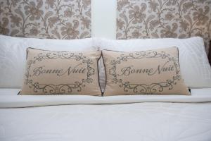 duas almofadas em cima de uma cama com lençóis brancos em The Craigmyle em Victoria