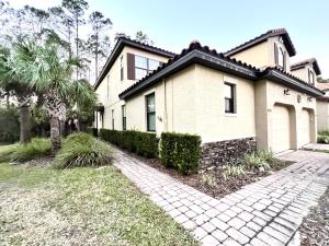 a house with a palm tree and a brick driveway at 8225RB-The Fountains at ChampionsGate townhouse in Kissimmee
