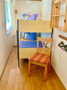 a small bedroom with a bunk bed and a chair at Ferienwohnung Peters in Trebel