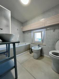 a bathroom with a sink and a toilet and a tub at Casa Robin in Montemarciano