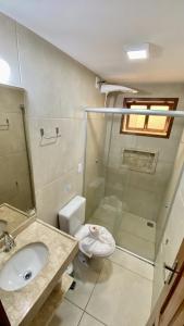 a bathroom with a toilet and a sink and a shower at Pousada Sunbrazil in Jericoacoara