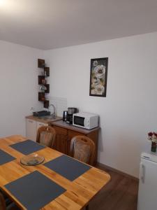 eine Küche mit einem Holztisch und einer Mikrowelle in der Unterkunft Ludo in Făgăraş