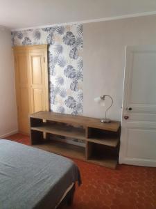 ein Schlafzimmer mit einem Bett und einem Schreibtisch mit einer Lampe in der Unterkunft La baieta in Moulinet