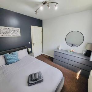 - une chambre avec un grand lit blanc et un miroir dans l'établissement Cozy Luxurious Apartment, à Edgware