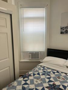 a bedroom with a bed and a window with a air conditioner at Hollywood Rentals LLC in Chicago