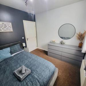 a bedroom with a blue bed and a mirror at Cozy Luxurious Apartment in Edgware