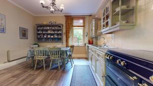 Una cocina con una mesa y sillas y un fregadero. en Elgin Tower apartment, en Minehead