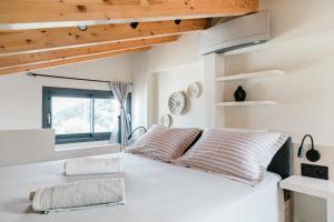a bedroom with a large white bed with wooden ceilings at Villa Tempestini in Nikiana